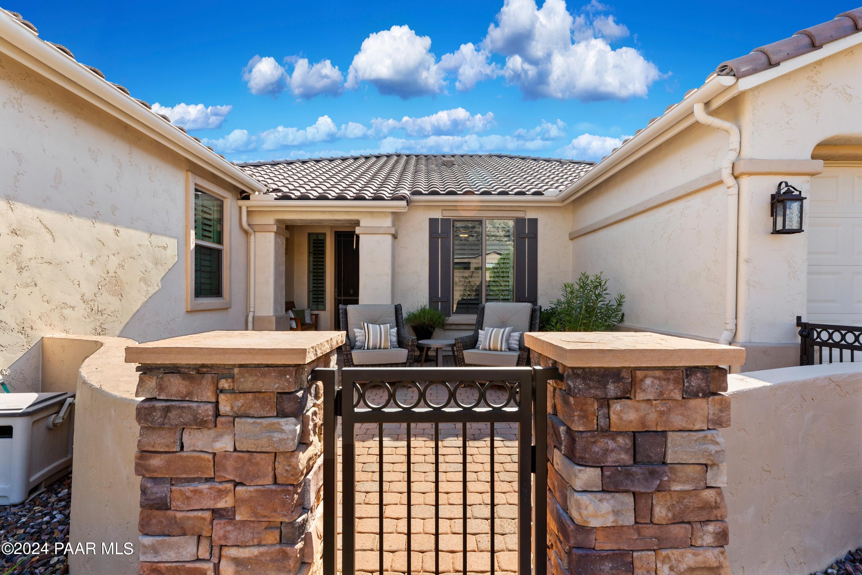1219 Stack Rock Road Prescott Valley, AZ 86314 - Photo 4 of 41 a view of a patio with table and chairs potted plants with wooden floor and fence