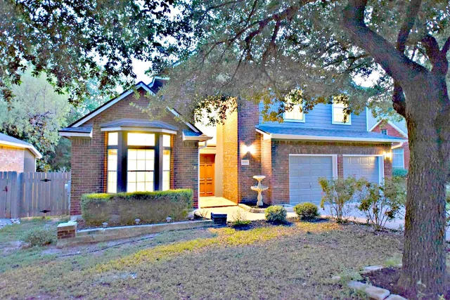 a view of a house with a tree and a yard
