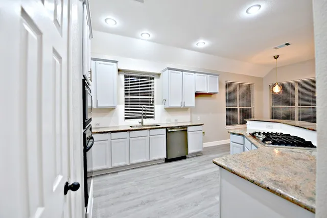 a kitchen with stainless steel appliances granite countertop a stove and a sink