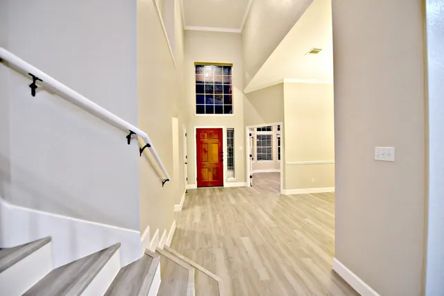 a view of a living room with wooden floor and stairs