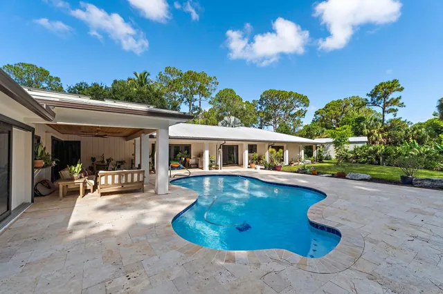 a view of a house with swimming pool and sitting area