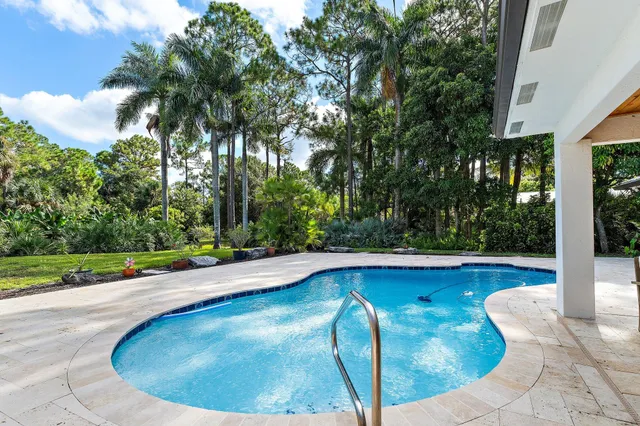 a swimming pool with outdoor seating and yard