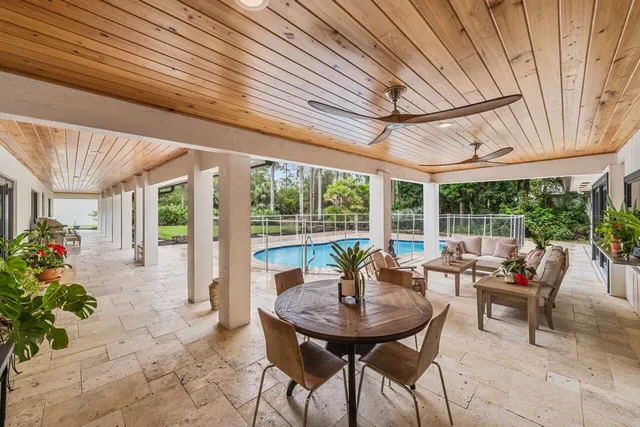 a view of a patio with a table chairs and a backyard