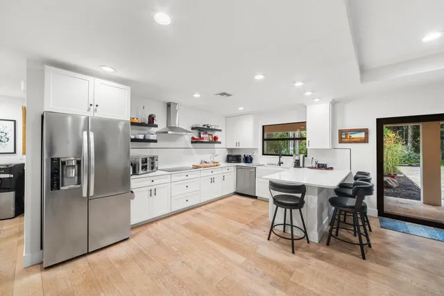 a kitchen with stainless steel appliances kitchen island granite countertop a refrigerator and a stove top oven