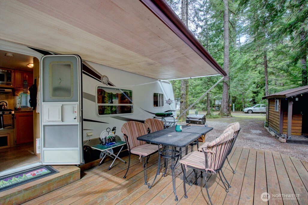 71 Wilderness Way Deming, WA 98244 - Photo 10 of 30 a view of a patio with a dining table and chairs with wooden floor and fence