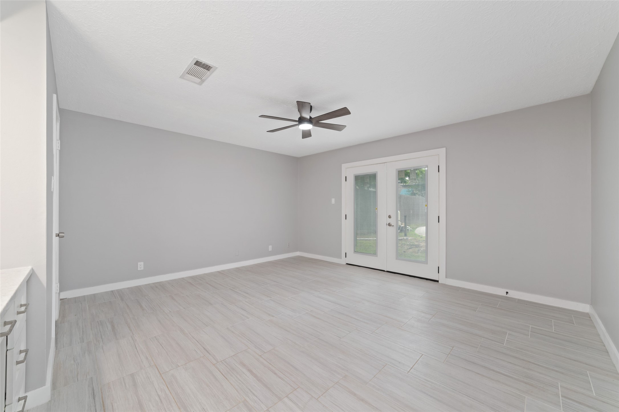 7910 Oak Moss Drive Spring, TX 77379 - Photo 13 of 38 Whole new primary bedroom with new tile, ceiling fan, and a double door that opens to the pool in the backyard.
