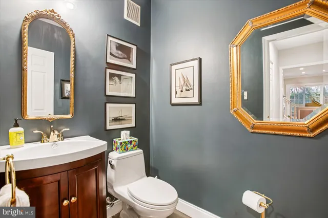 a bathroom with a toilet a sink and mirror