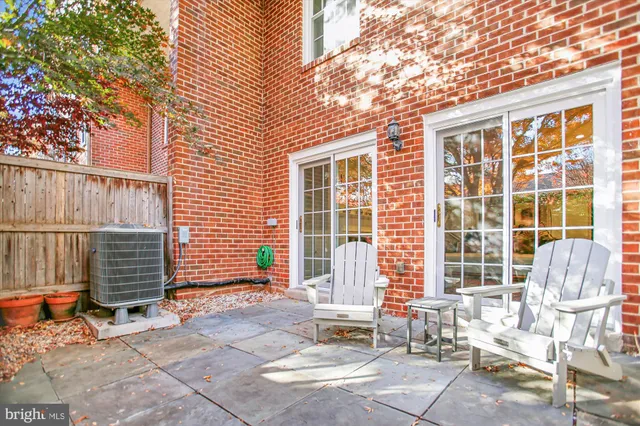 a backyard of a house with large trees and outdoor seating