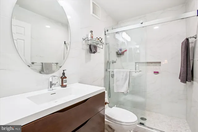 a bathroom with a sink a toilet and shower