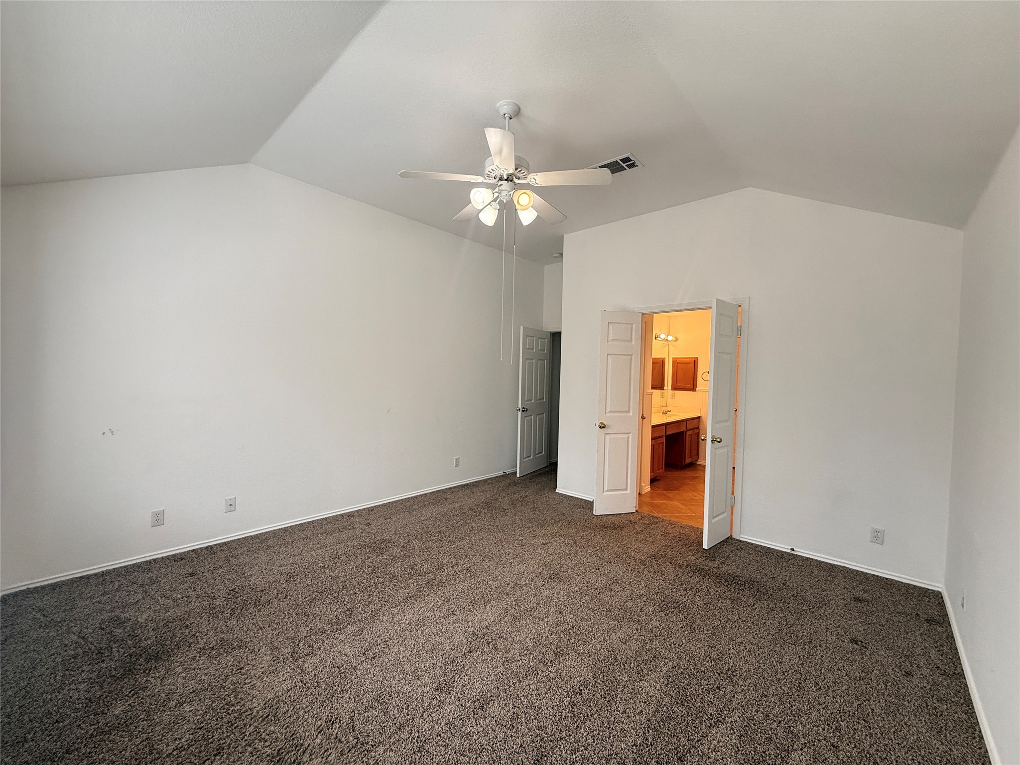 708 Spring Brook Lane Leander, TX 78641 - Photo 12 of 27 Unfurnished bedroom featuring ensuite bath, dark carpet, and a ceiling fan