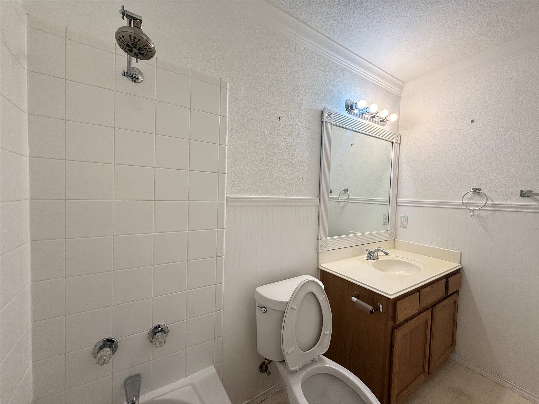 708 Spring Brook Lane Leander, TX 78641 - Photo 19 of 27 Bathroom with shower / washtub combination, vanity, a textured wall, crown molding, and a wainscoted wall
