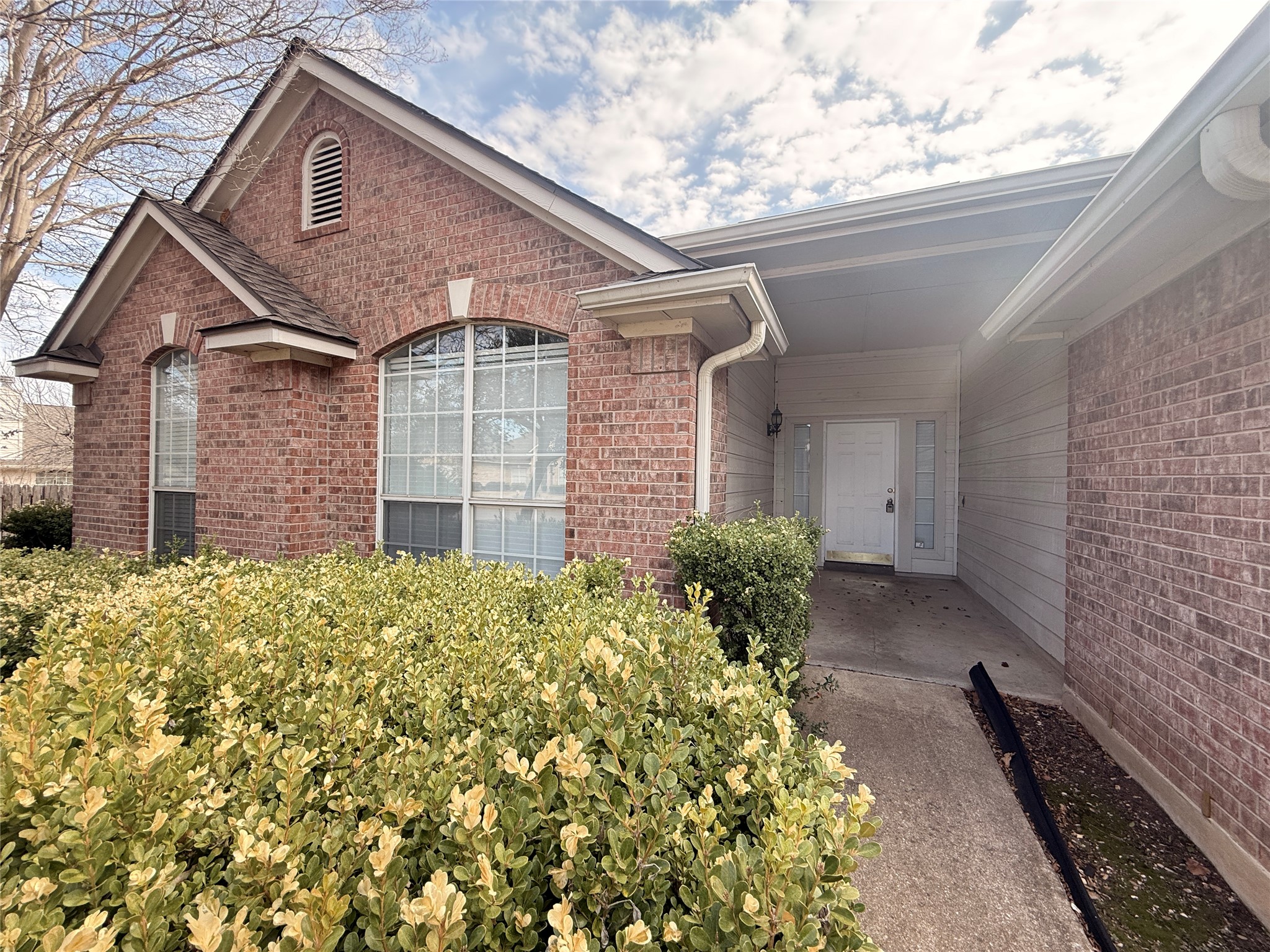 708 Spring Brook Lane Leander, TX 78641 - Photo 4 of 27 View of exterior entry featuring brick siding and a patio