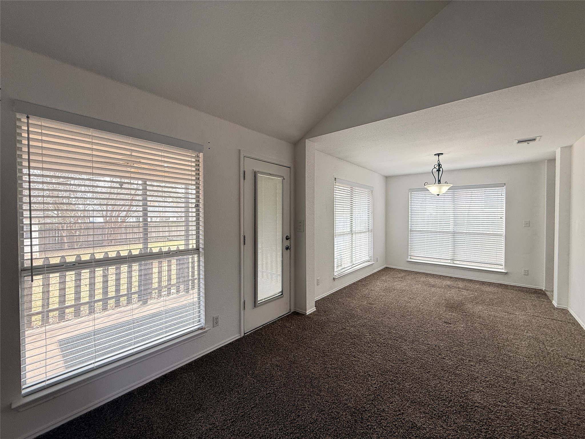 708 Spring Brook Lane Leander, TX 78641 - Photo 10 of 27 Empty room with vaulted ceiling and dark carpet