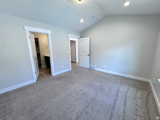 12339 Remy Road, Unit 422 Herriman, UT 84096 - Photo 25 of 36 Unfurnished bedroom featuring vaulted ceiling, ensuite bathroom, carpet flooring, and recessed lighting