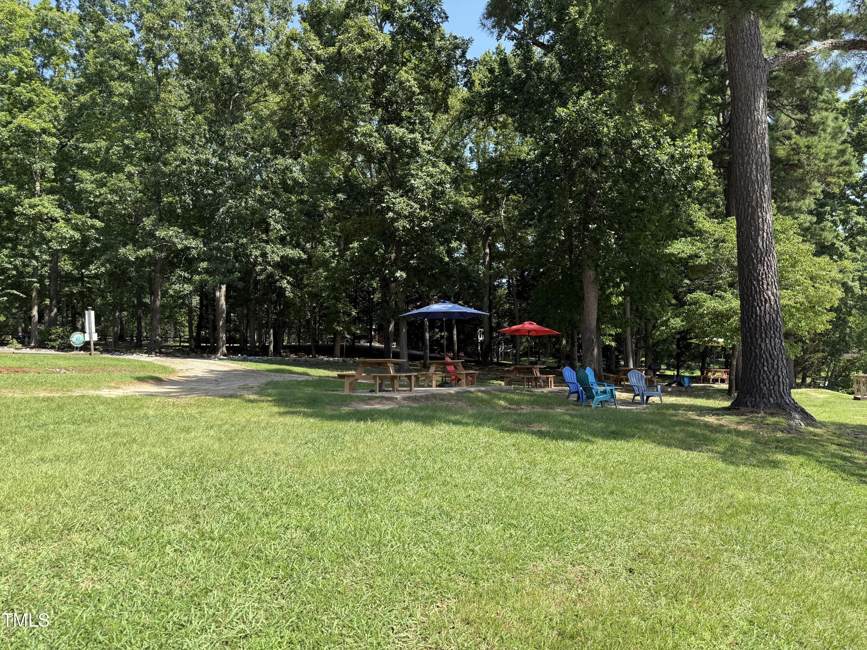 0 Summer Place Macon, NC 27551 - Photo 14 of 19 a view of a swimming pool with a table and chairs under an umbrella