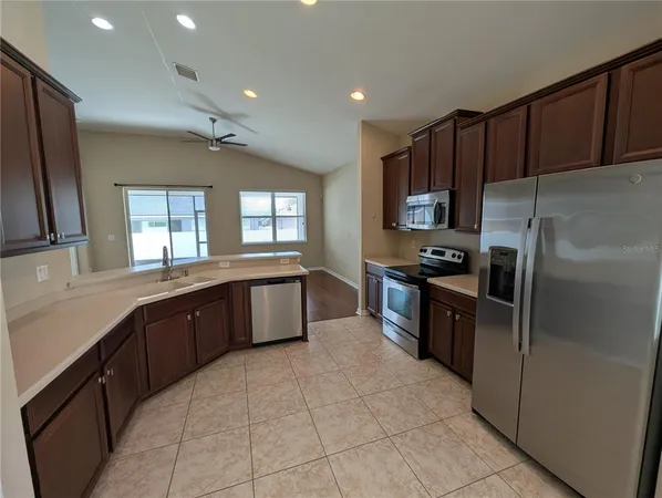 a kitchen with granite countertop wooden cabinets and stainless steel appliances