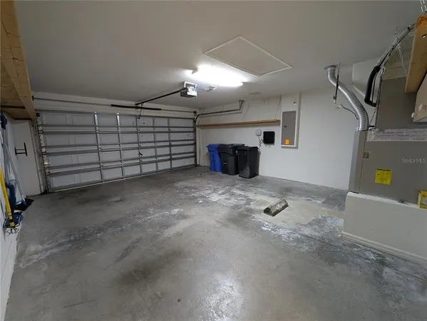 an empty room with kitchen view and fireplace