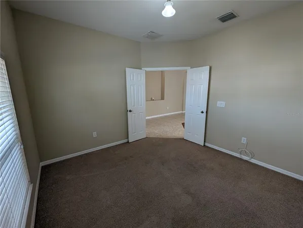 an empty room that has a large mirror and vanity
