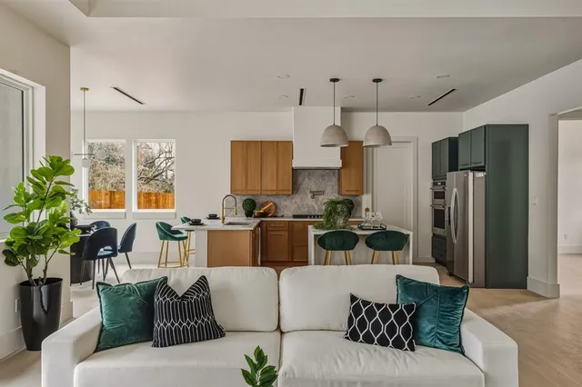 a living room with furniture white walls and a chandelier
