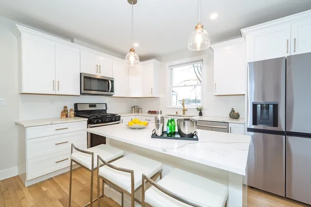 a kitchen that has a lot of cabinets a sink and appliances in it
