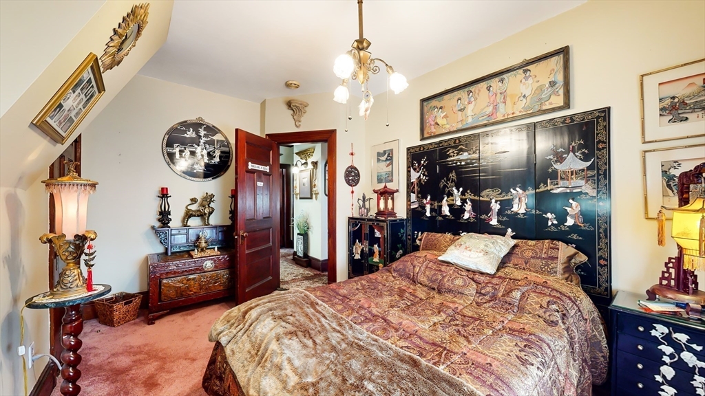 52 Thornton Park Winthrop, MA 02152 - Photo 23 of 40 a bed room with a bed mirror and a chandelier