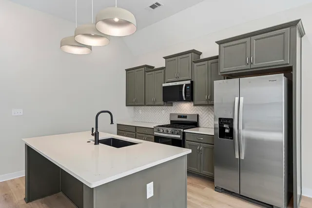 a kitchen with stainless steel appliances a refrigerator a stove a sink and dishwasher