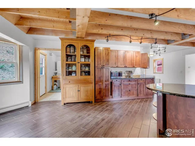 a kitchen with stainless steel appliances wooden floor and more cabinets