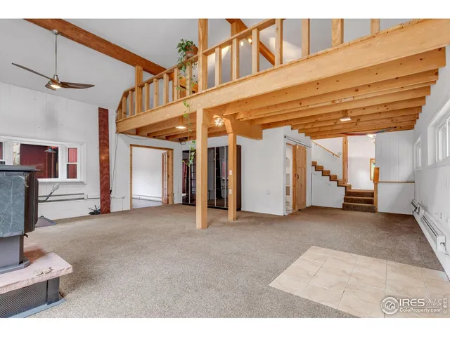 a view of a big room with an entryway and a ceiling fan