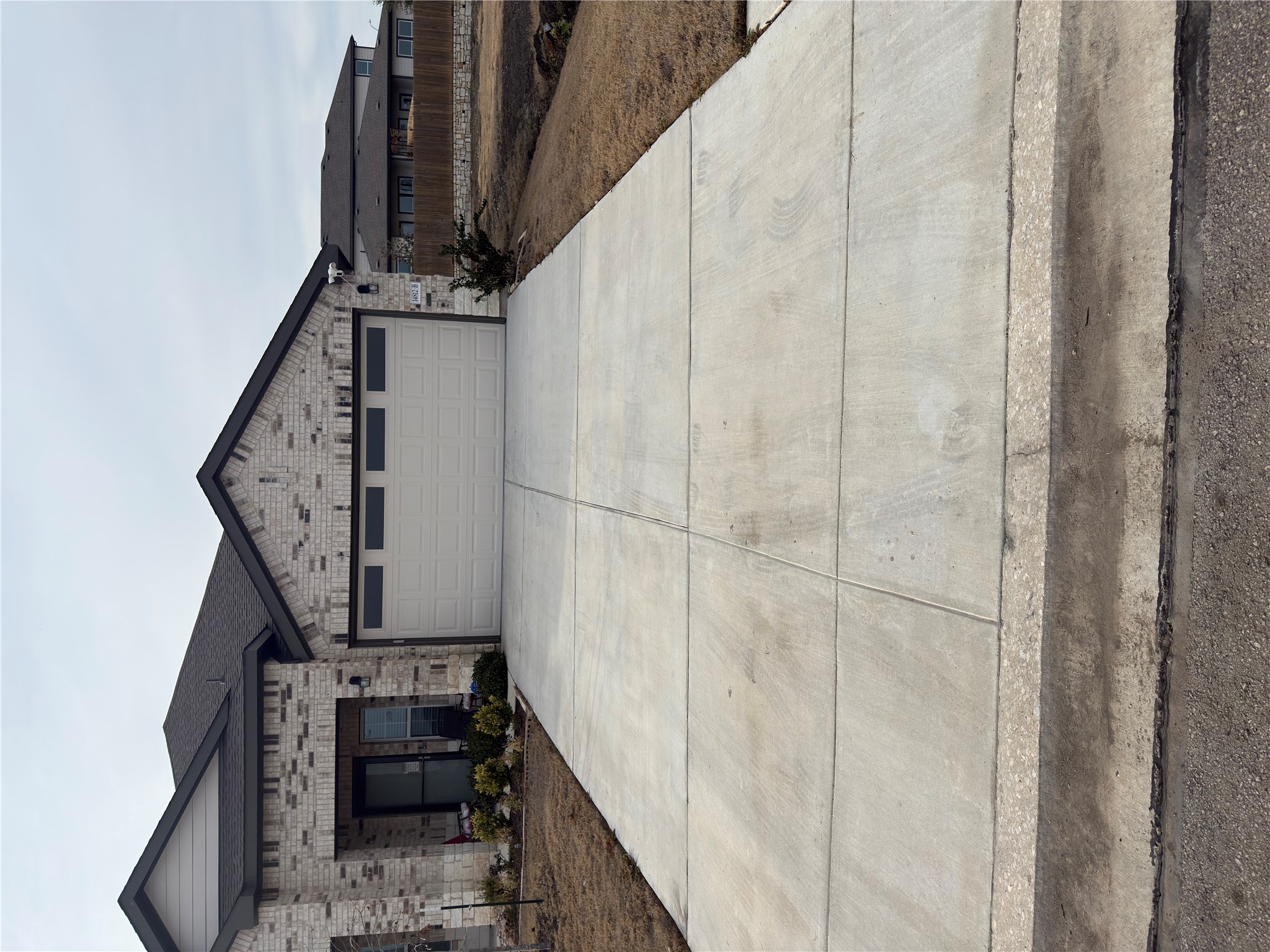 View of front of property with brick siding, driveway, and a garage
