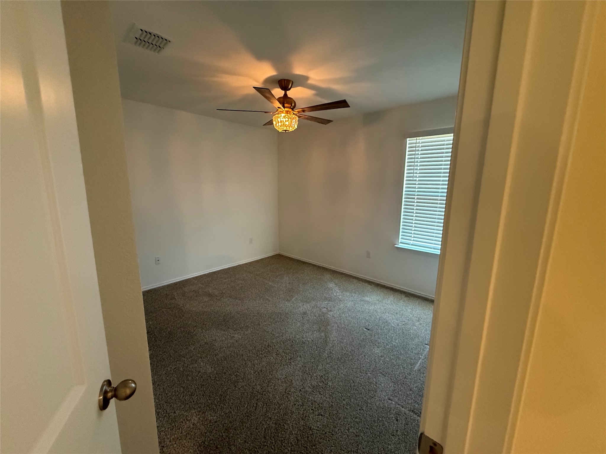 14812 Perlino Way Manor, Unit B Austin, TX 78721 - Photo 4 of 11 Spare room with carpet and a ceiling fan