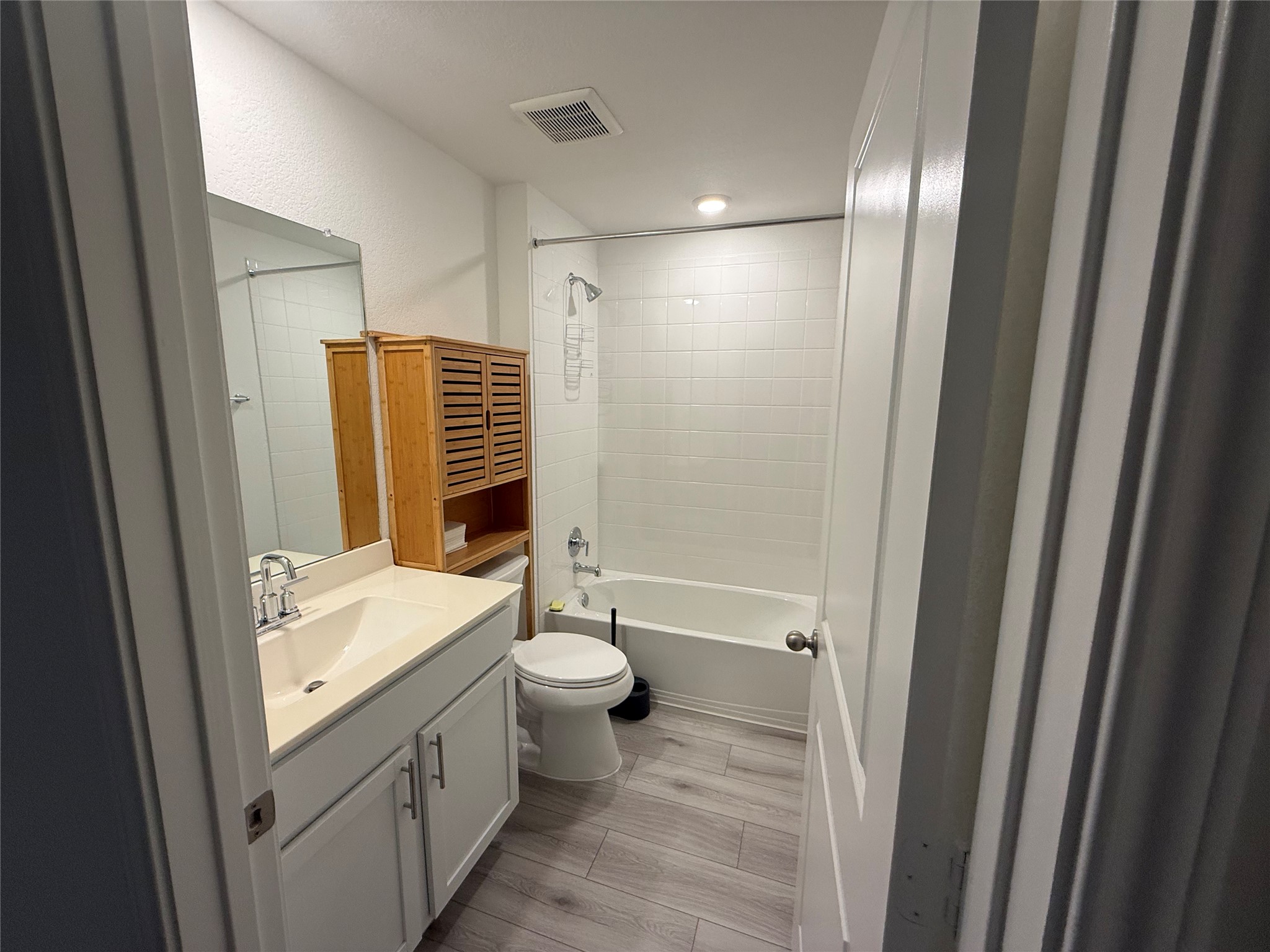 14812 Perlino Way Manor, Unit B Austin, TX 78721 - Photo 5 of 11 Bathroom with vanity, shower / bath combination, and a textured wall