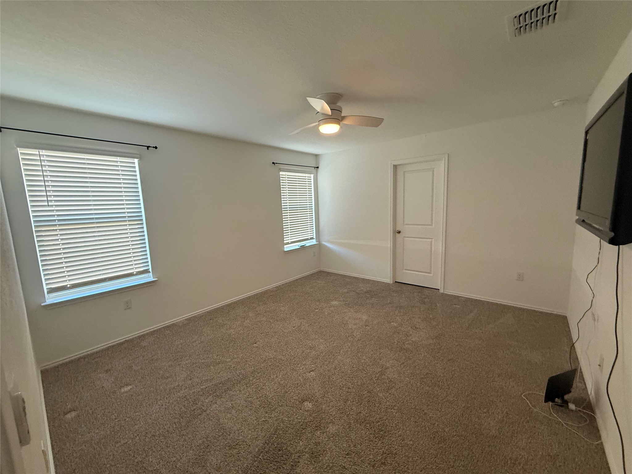 14812 Perlino Way Manor, Unit B Austin, TX 78721 - Photo 6 of 11 Spare room featuring carpet flooring and a ceiling fan