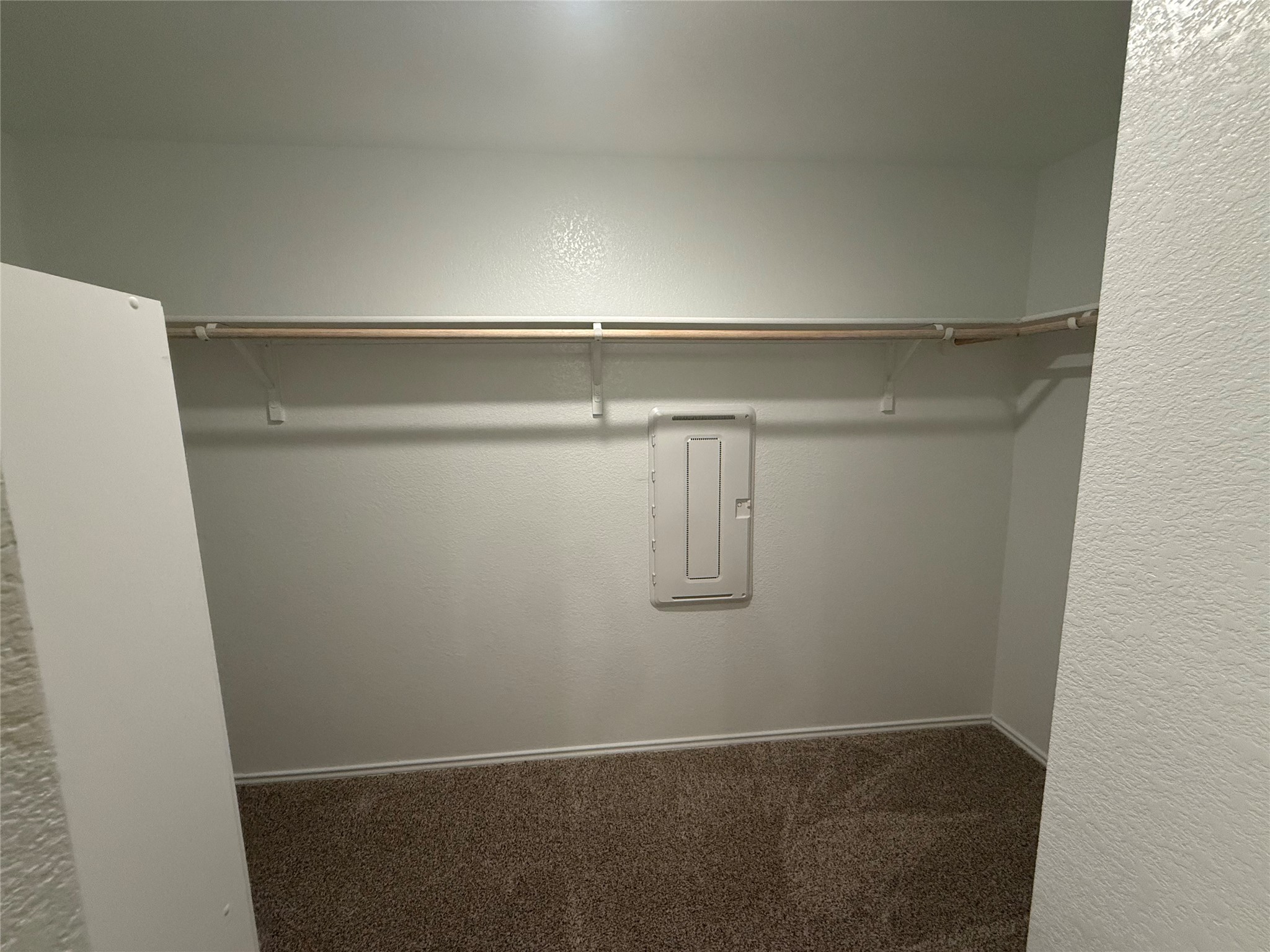 14812 Perlino Way Manor, Unit B Austin, TX 78721 - Photo 7 of 11 Walk in closet featuring carpet floors and electric panel