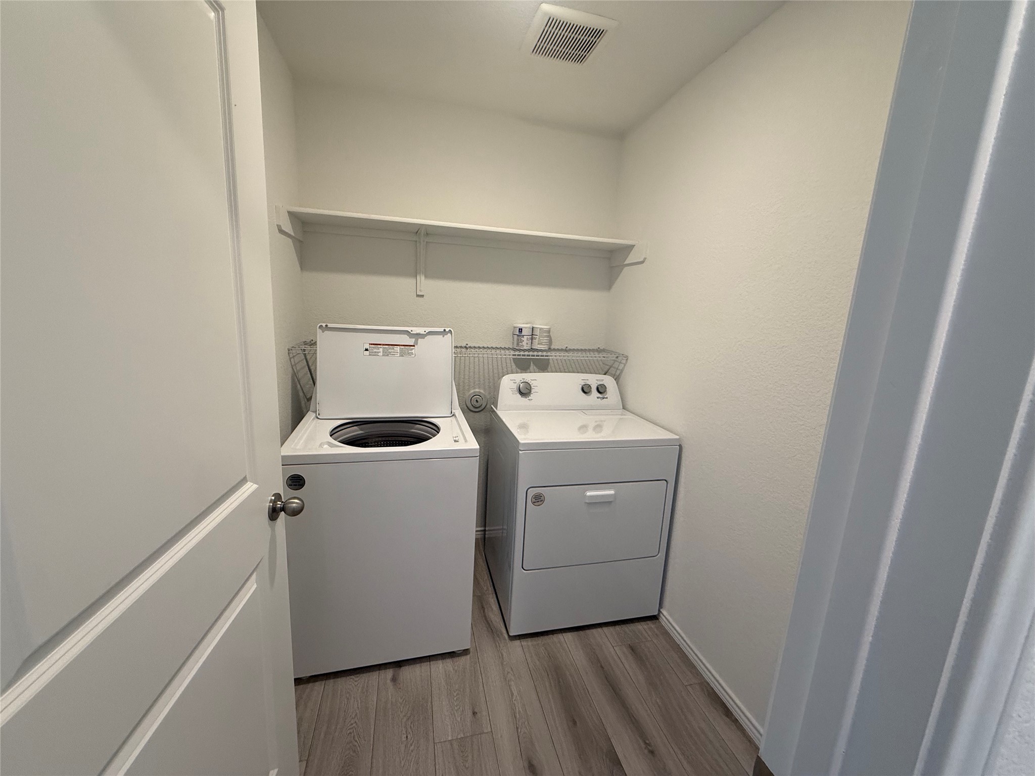 14812 Perlino Way Manor, Unit B Austin, TX 78721 - Photo 10 of 11 Laundry area with light wood finished floors and washer and dryer