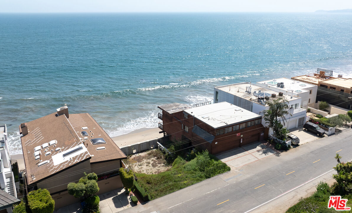 25260 Malibu Road Malibu, CA 90265 - Photo 5 of 13 a view of a terrace with lawn chairs and a floor to ceiling window