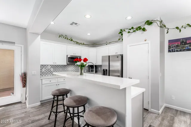 a kitchen with granite countertop a refrigerator and a stove top oven