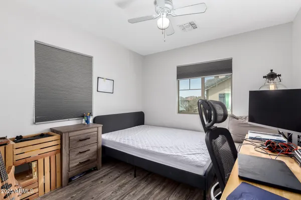 a bedroom with a bed and a flat tv screen on the dresser