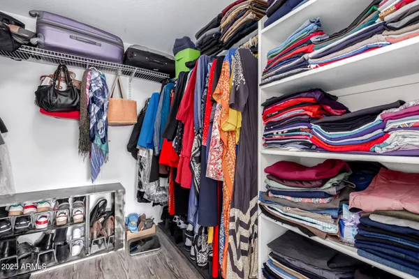 a view of walk in closet with clothes and shoes