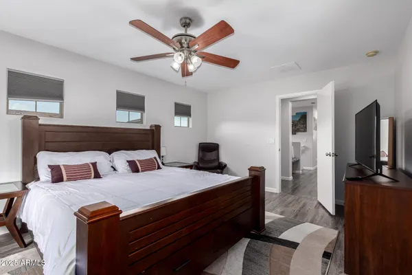 a bedroom with a large bed and a flat tv screen on a dresser