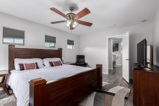 a bedroom with a large bed and a flat tv screen on a dresser