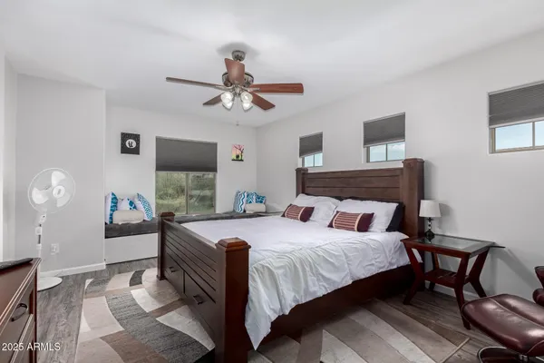 a bedroom with a bed a chandelier and a mirror on a dresser