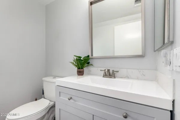 a bathroom with a sink a toilet and a mirror