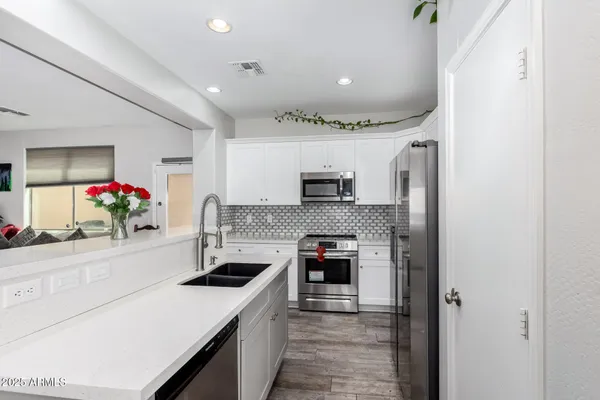 a kitchen with stainless steel appliances a sink stove and refrigerator