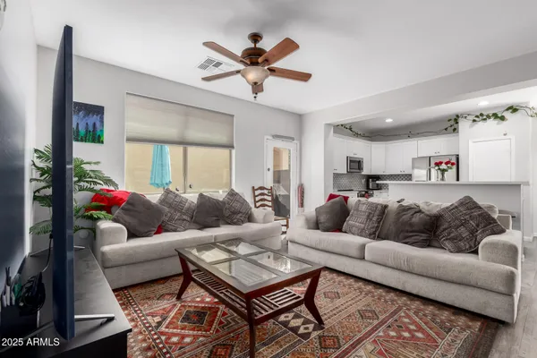 a living room with furniture and a ceiling fan