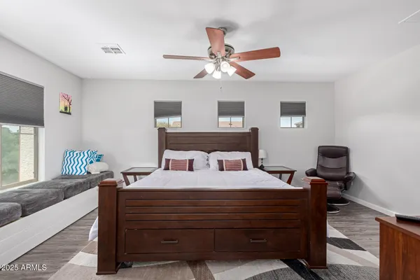 a bedroom with a bed and wooden floor