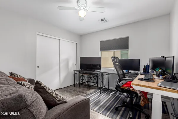 a bedroom with a bed and a computer on a desk