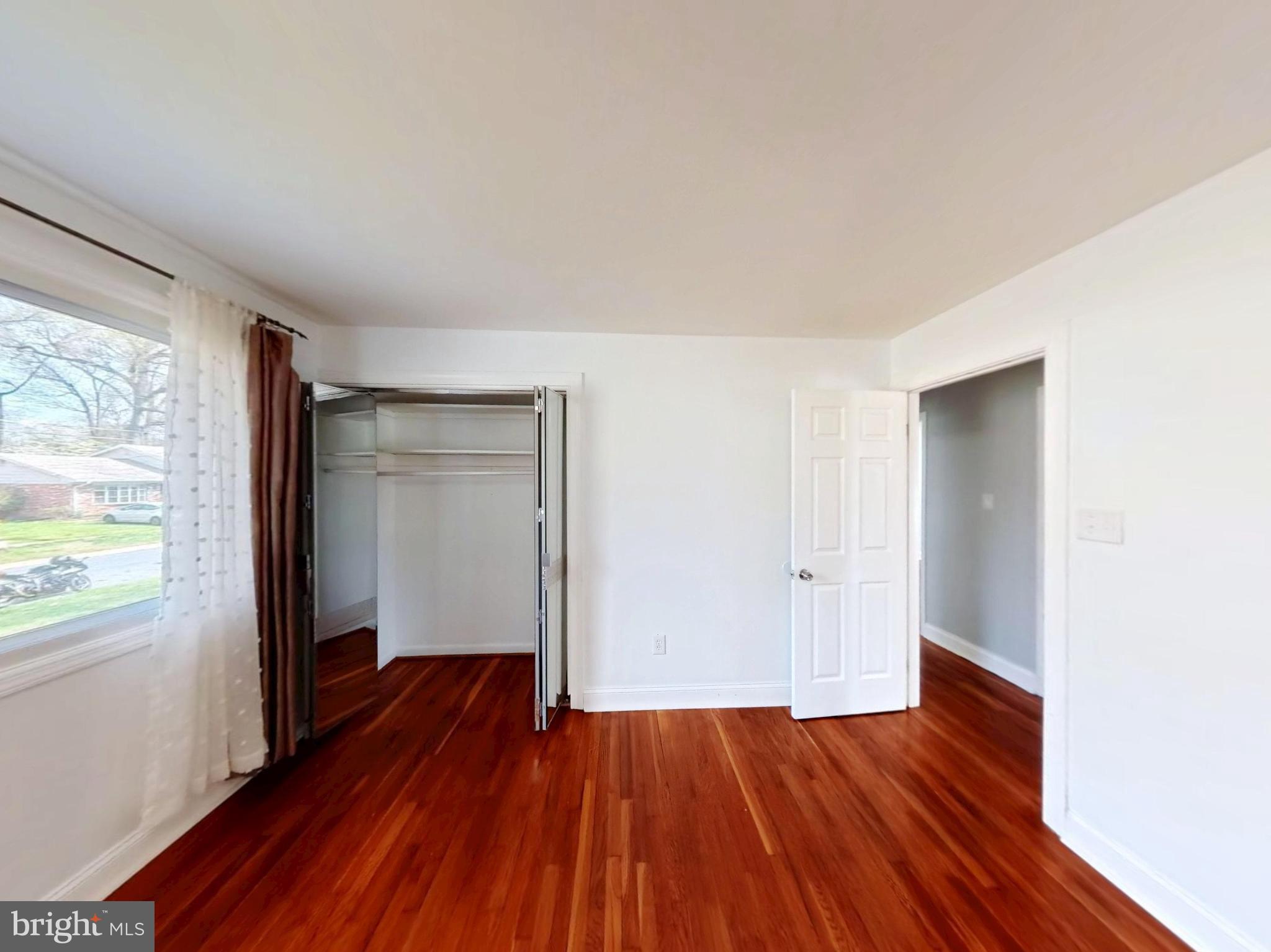 1012 Loxford Terrace Silver Spring, MD 20901 - Photo 18 of 52 an empty room with wooden floor and windows