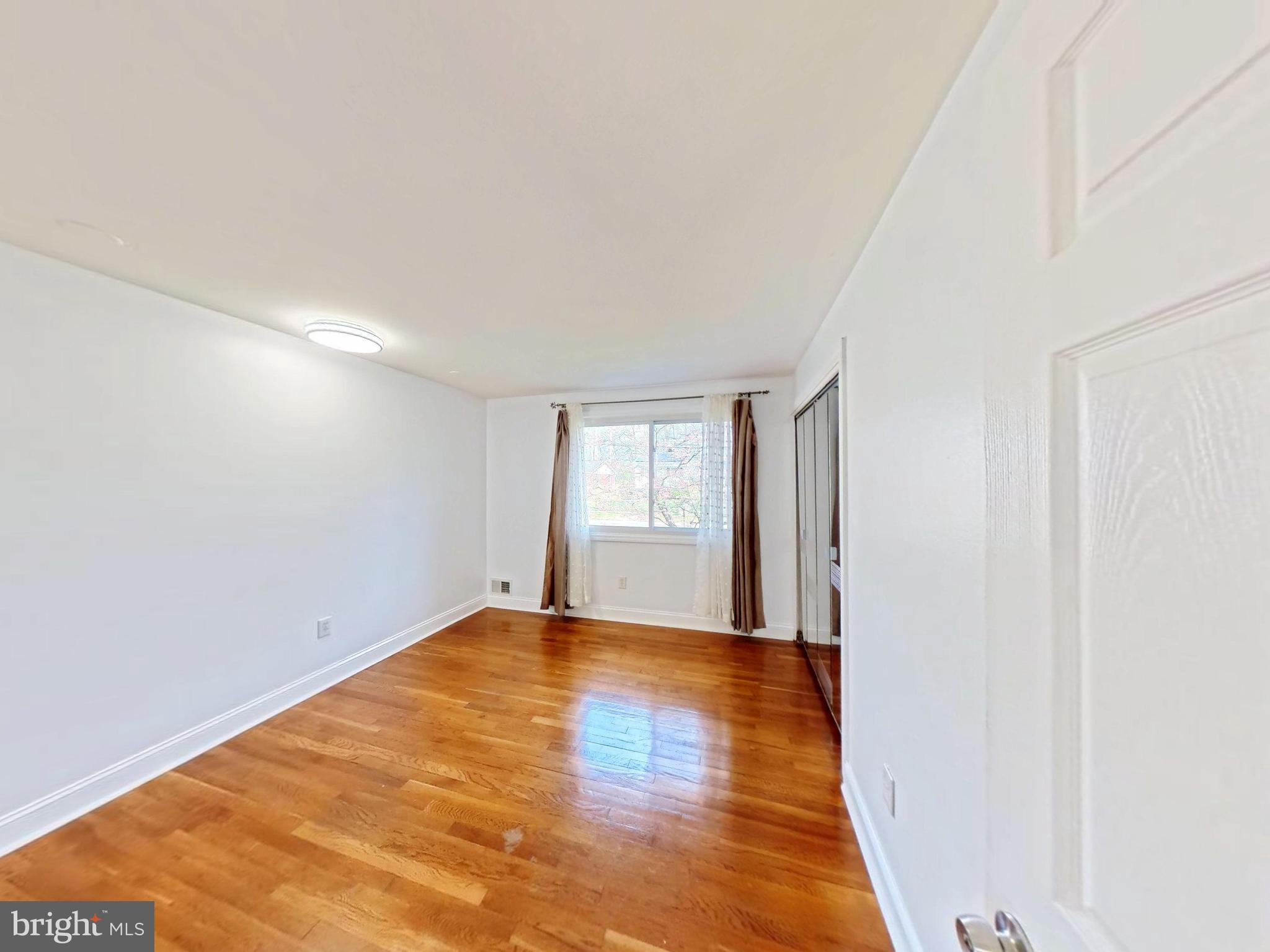 1012 Loxford Terrace Silver Spring, MD 20901 - Photo 39 of 52 a view of an empty room with wooden floor and a window
