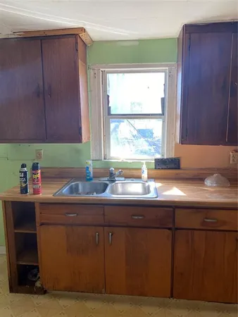 a kitchen with a sink cabinets and a window