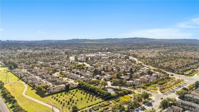 a view of a brick house with a small yard and wooden fence
